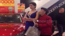 Old man uses selfie stick to take sneaky photos with model