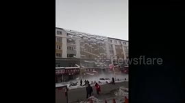 Massive load of snow falls off building after blizzard