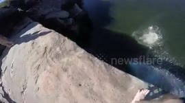Daredevils jump off high cliff in Australia into lagoon