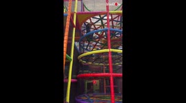 Goofy boy looks like a cartoon character brought to life as he falls down jungle gym