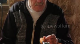 Palestinian man Akram al-Yaziji, 65, weaves on wooden loom, in Gaza city