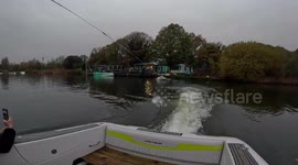 Daredevil surfs on ironing board dragging boat in UK