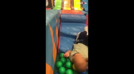 Carefree kid can't help but keep falling over in soft play area