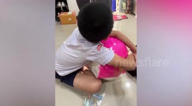 Emotional little boy cries while smashing piggy bank with his impressive savings inside