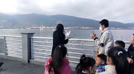 Chinese woman catches seagull and poses for photos with it