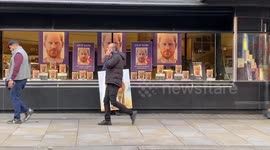 Artist poses with painting depicting Prince Harry as Don Quixote outside London bookstore