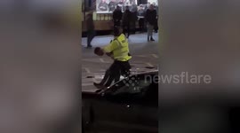 Shocking footage shows a police officer pushing a football fan to the ground