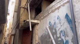 Palestinians inspect a damaged house following an Israeli military raid
