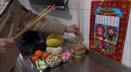 A Man Burns Incense To Worship The God of The Kitchen in Yichang, China