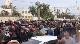Mourners carry the bodies of three Palestinians who were killed during an Israeli raid