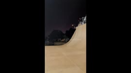 Skateboard crashes dropping in on huge half pipe and splats into the wall on the other side