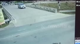Motorcycle rider somehow survives crash between two pickup trucks