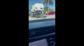 Lazy or genius? Miami cyclist hangs off back of vehicle truck