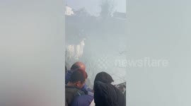 Residents climb on plane crash wreckage in Nepal that killed at least 69