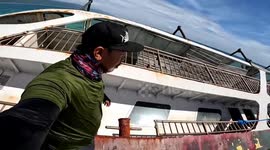 Curious locals explore rusty shipwreck which sank in the Philippines