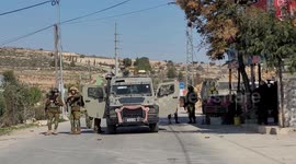 Israeli soldiers stand guard at the scene in the village of Halhul