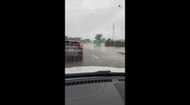 Woman genuinely concerned about her car stalling while driving through flood water