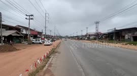 Kind resident holds up telephone cables and cleans road to help truck drivers pass through