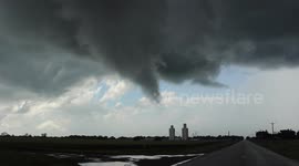 Car Backing Away from Large Funnel Cloud