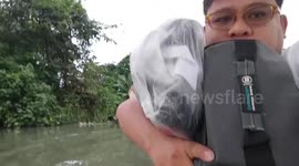 Families escape chest-deep floods swamping villages in the Philippines