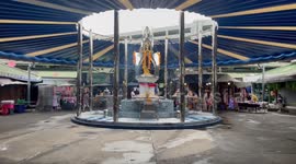 Thai locals burn incense sticks and prays at Buddhist shrine built inside market
