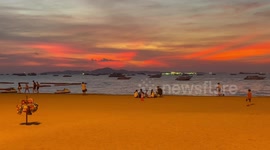 Bright orange sunset shines over beach in Thailand