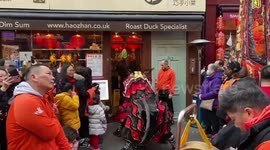 Chinese lion brings good luck to businesses in London’s Chinatown on the eve of the Year of the Rabbit