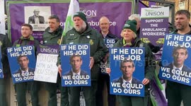Ambulance workers hold banners against British PM Rishi Sunak