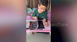 Talented schoolboy tattoos detailed patterns on fake skin sheet to practice in Thailand