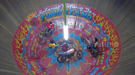 An young girl performing breath taking bike stunt together with two men