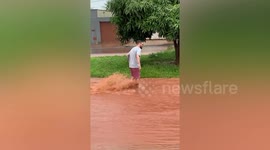 Man casually walks through flash flood torrents to get beer