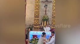Self-conscious bride uses mouth spray before first kiss at wedding