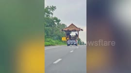 Family relaxes on gazebo hut at back of moving pickup truck