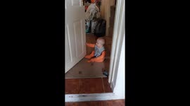 Adorable scene as baby makes himself giggle by moving squeaky door