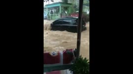 Homes and cars dragged away by flood water in Manado, Indonesia