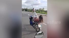Daredevil motorcyclist arrested over 'reckless riding' laying on bike with feet in air