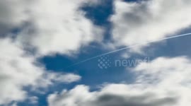 Time-lapse of fast moving clouds with aeroplane trails visible in the sky
