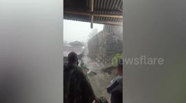 People scream as home's wall collapses onto neighboring property after heavy rains in Manado, Indonesia