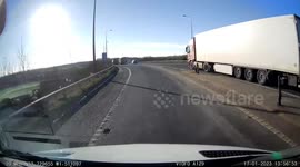 Impatient angry car driver undertakes tipper truck and brake checks them nearly causing accident on M1 motorway slip road