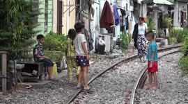 Children play on railway track that runs through notorious Bangkok slum