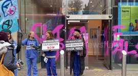 Activists spray paint reading 'Climate criminals' on Barclays' window in London