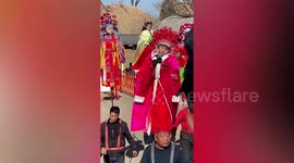 Boy falls asleep despite being held in the air during Chinese New Year performance