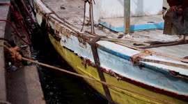 Palestinian fishermen work on their fishing boats at the sea port of Gaza City