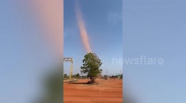 Dust devil tornado picks up orange dust at construction site