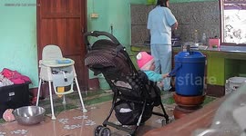 Curious baby pulls jar over spilling water over kitchen floor