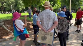 Stand off with police as woman holding sign initially refuses to give police idea in Sydney, Australia