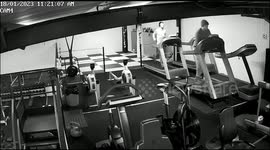 Man falls off treadmill while taking sweater off and knocks man behind him off another treadmill