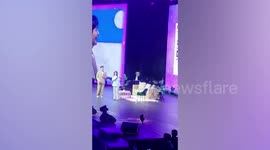 K-pop artist stunned as excited fan girl in wedding gown climbs on stage