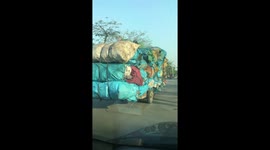 Dangerously overloaded 3-wheeler driven down road in Vietnam