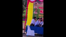 One child accidentally hits another child's back while performing at a cultural celebration